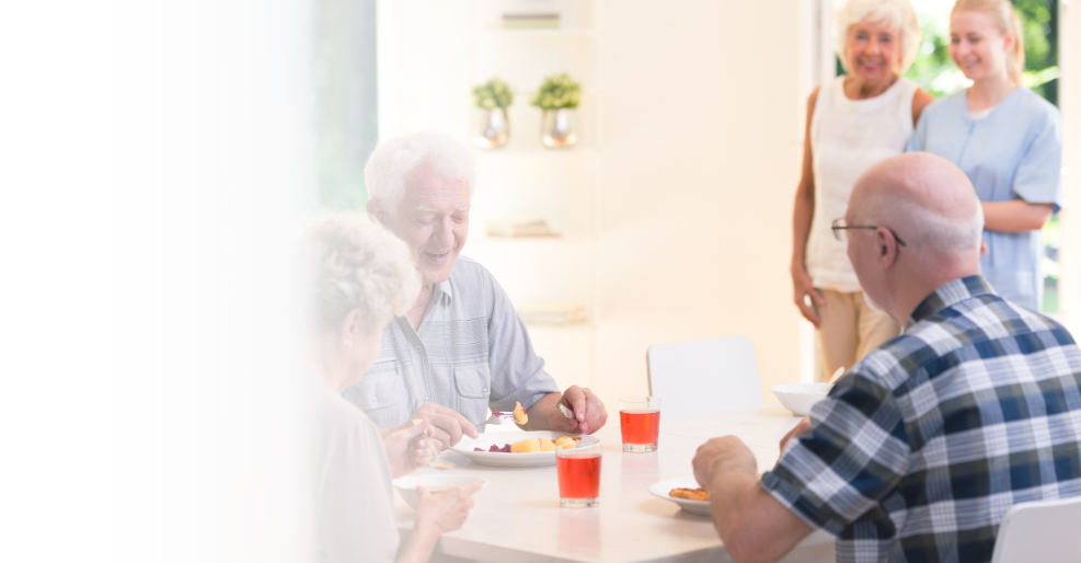 A group of seniors sitting at a table talking and laughing.